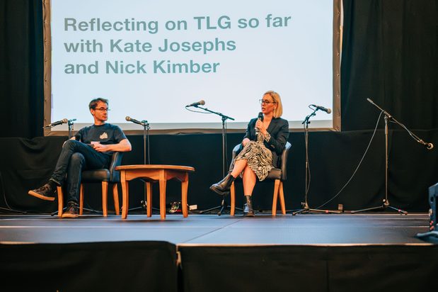 Nick Kimber and Kate Josephs on stage presenting at the One Year On event